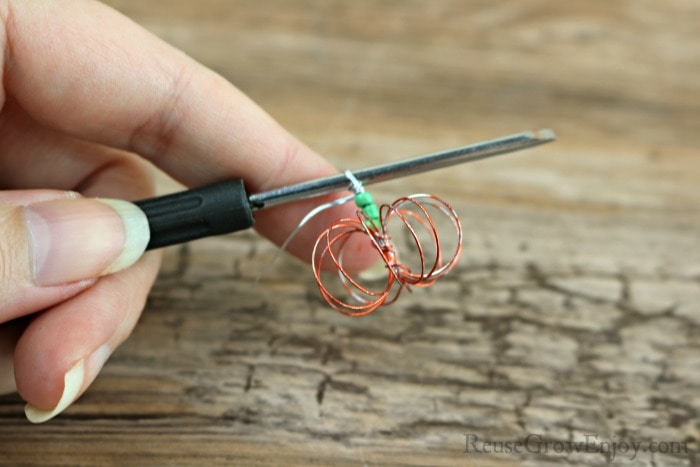 Twist wire to make a loop over beads