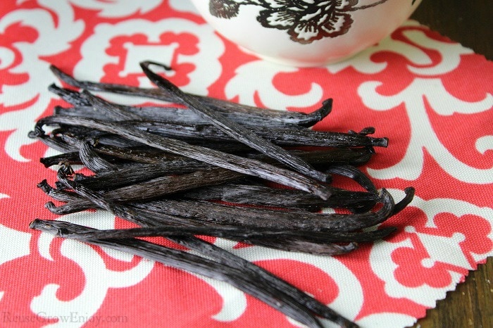 Pile of whole vanilla beans on laying on red cloth
