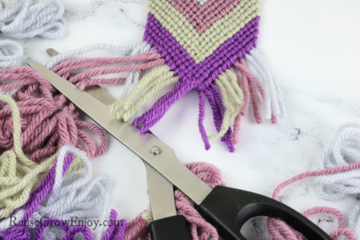 Scissors cutting off ends of yarn