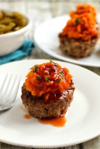 White plate with whole30 meatloaf sweet potato muffins on it.