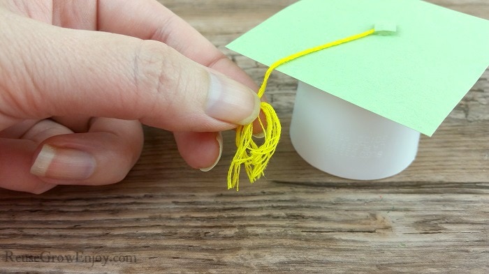 Fingers pulling sting apart to look like a tassel.