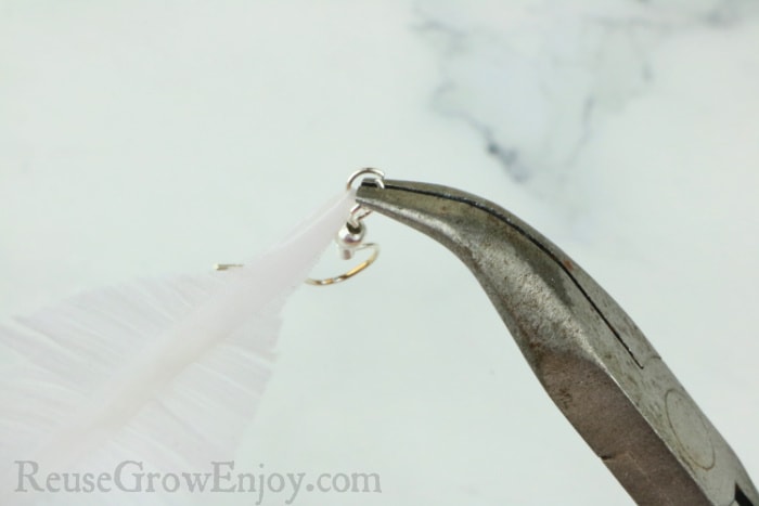 jump ring being pinched on with pliers